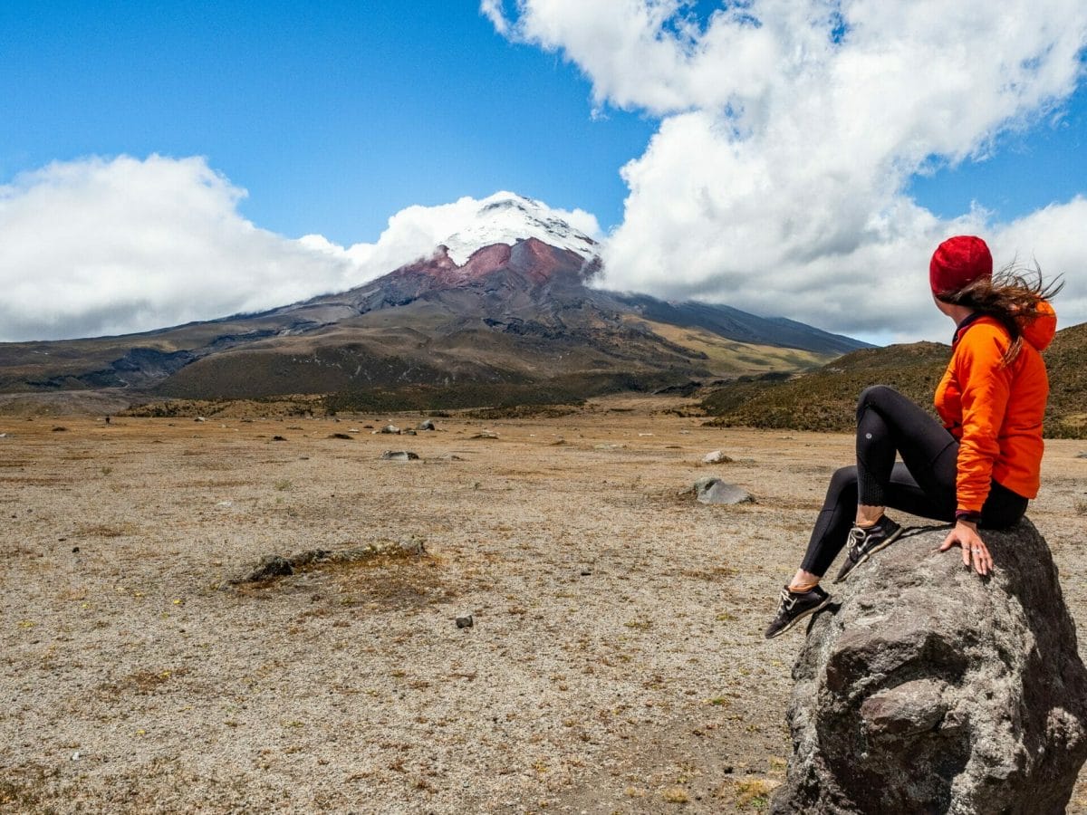 Girl on rock in front of Cotopaxi Volcano